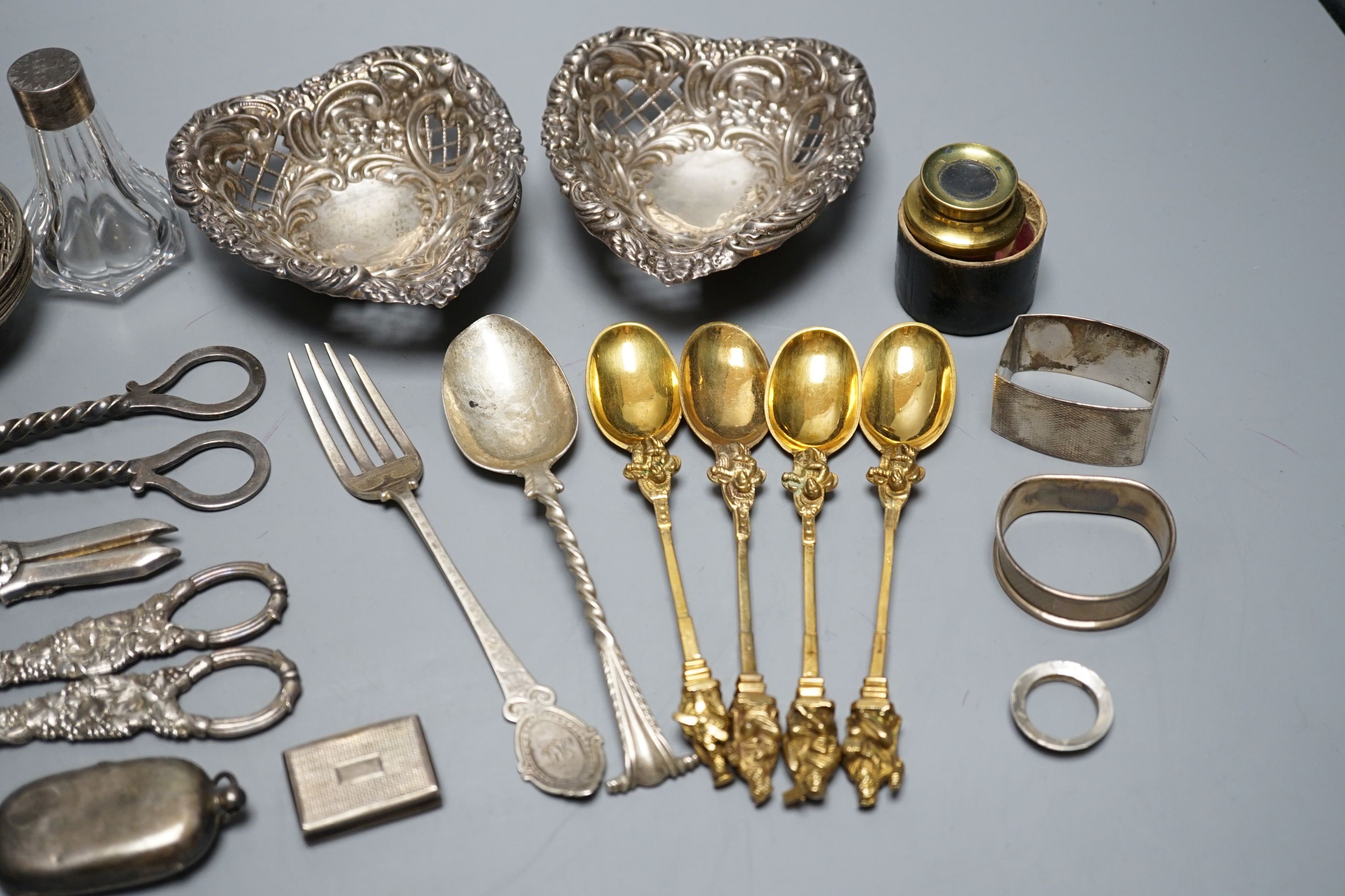 A cased Victorian silver part communion set, a silver cigarette case, two silver napkin rings, a set of five pierced silver bonbon dishes, a pair of Victorian silver grape shears, Georgian silver vinaigrette, pair of sil